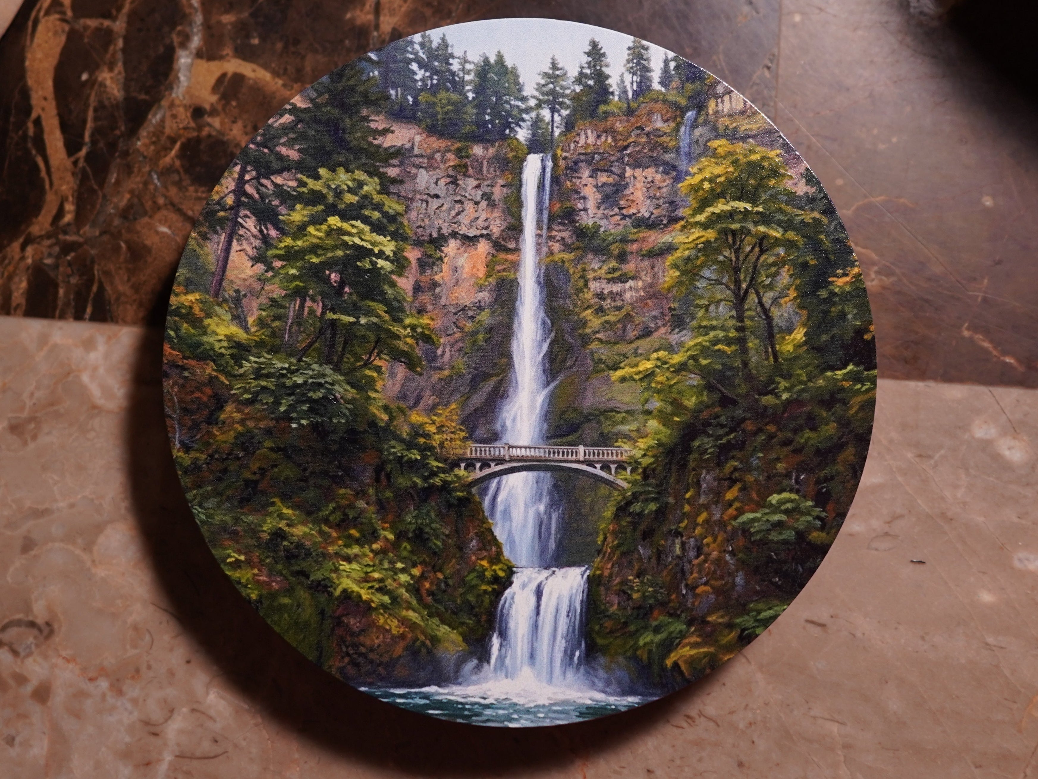 Round coaster with a waterfall design on a marble surface