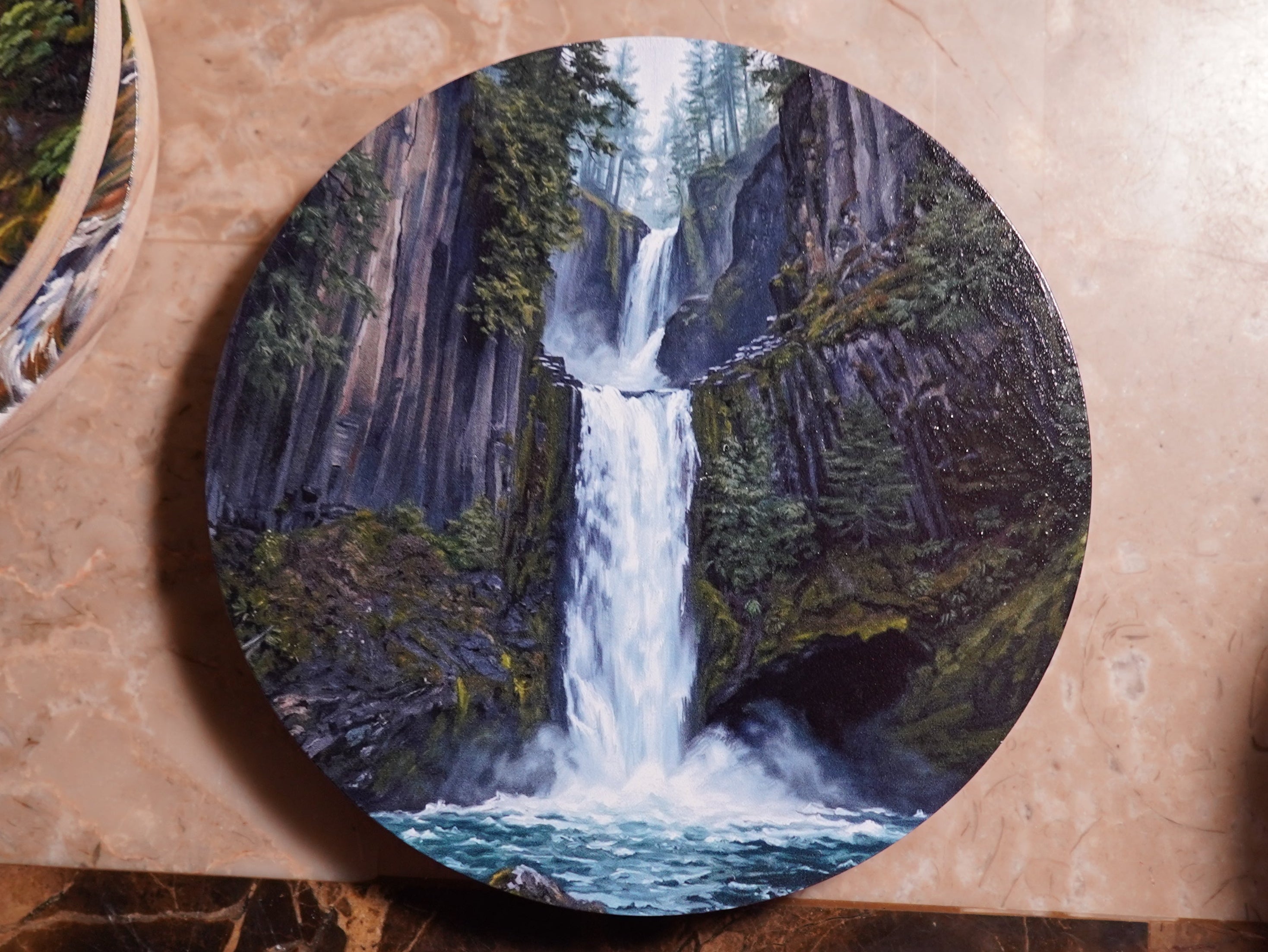 Set of round coasters with waterfall design on a marble surface